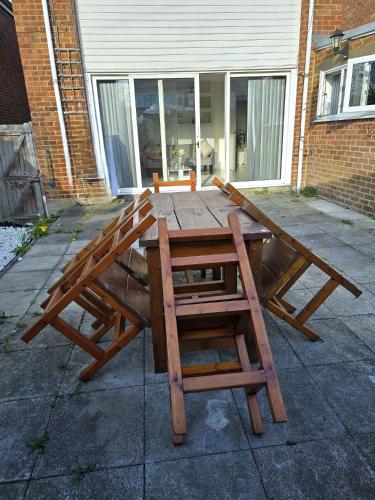 a wooden picnic table in front of a house at Large House, Home for Contractors- Park Free in Chatham