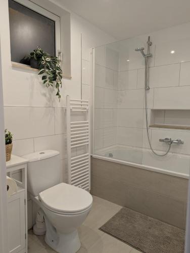 a white bathroom with a toilet and a bath tub at Wohlfühl Apartment ruhig wohnen, alles vor Ort nähe der Niederlande in Gangelt