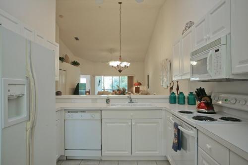 eine weiße Küche mit weißen Schränken und einer Spüle in der Unterkunft Golf course views - 2BR, 2nd floor condo - Heritage Oaks in Vamo
