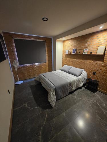 a bedroom with a large bed and a flat screen tv at Colonia Americana Apartment in Guadalajara