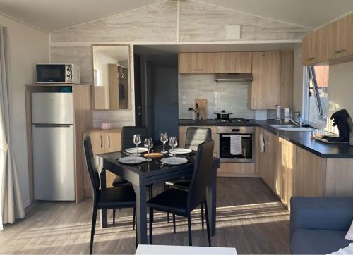 une cuisine avec une table et des chaises dans une cuisine dans l'établissement Chalet bois, à Torcy-le-Petit