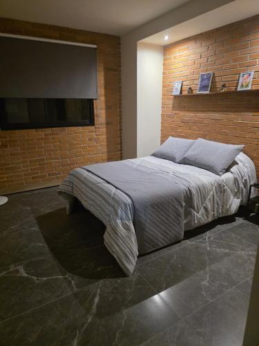 a bedroom with a bed and a flat screen tv at Colonia Americana Apartment in Guadalajara