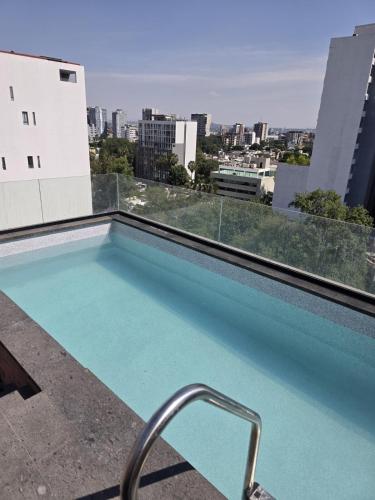 a swimming pool on the roof of a building at Colonia Americana Apartment in Guadalajara