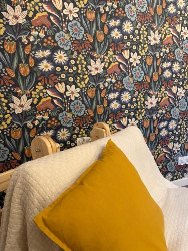 a bedroom with a floral wallpaper and a bed with a yellow pillow at Potęgówka wege Kaszuby in Linia