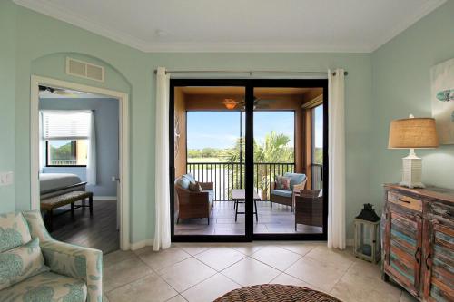 a living room with a door open to a balcony at Lakefront 3rd floor condo at River Strand Golf and Country Club in Bradenton