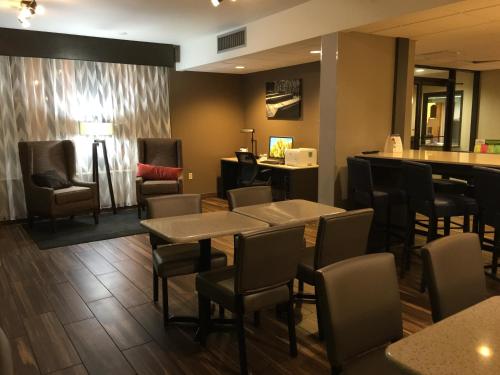 a restaurant with tables and chairs and a bar at Baymont by Wyndham Rocky Mount I-95 in Rocky Mount
