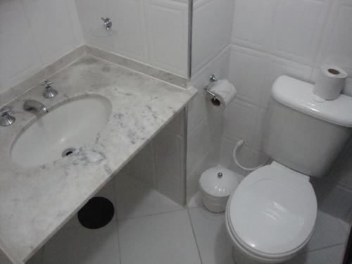 uma casa de banho branca com um lavatório e um WC em Hotel San Marco em São José dos Campos