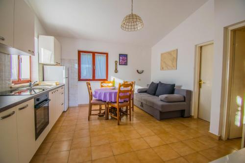 a kitchen and living room with a table and a couch at Apartment Rino, only 30m from the sea in Pag