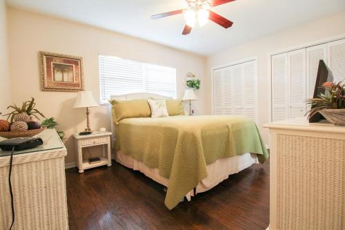 サラソタにあるCharming lakefront condo located in the desirable community of Palm Aireのベッドと天井扇風機のある寝室