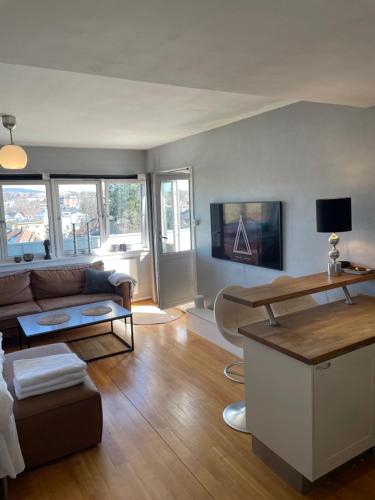 een woonkamer met een bank en een tafel bij Frogner Gården Penthouse Terrasse in Oslo