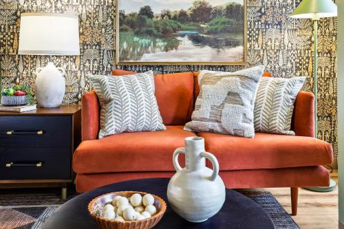 an orange couch in a living room with a table at Quest Travels in Seattle
