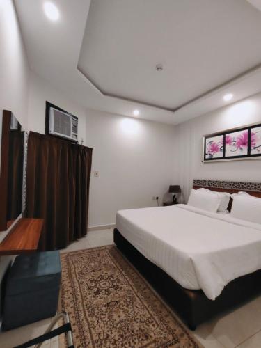 a bedroom with a large bed and a television at منتجع شاطئ الدولفين للإيواء السياحي in Yanbu