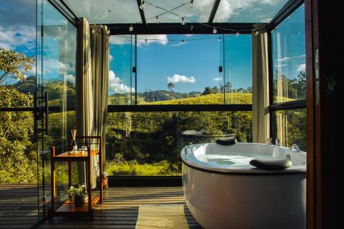 a large bathroom with a tub in front of a window at Cabana Mantiká in Sapucaí-Mirim
