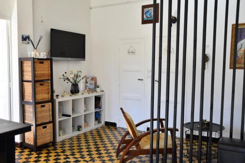 una habitación con una mesa y una silla y un televisor en Légèreté aux Mûriers, en Le Lavandou