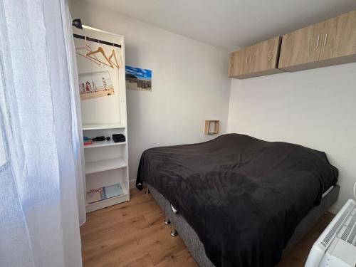 une chambre avec un lit et une étagère dans l'établissement Les Ondines, à Le Touquet-Paris-Plage