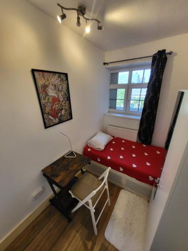 a small room with a red bed and a desk at Marvellous property for 8 people in Battersea - Zone 1, 3 min walking from the main Station in London