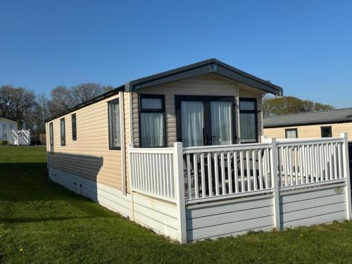 a tiny house with a white fence in a yard at Two bedroom Holiday Home with countryside view in St Austell