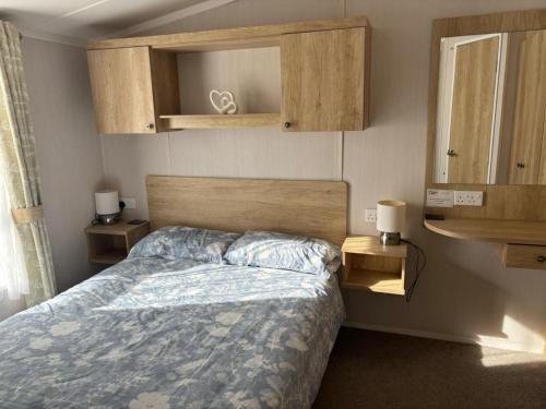 una camera da letto con un letto con un piumone blu di Two bedroom Holiday Home with countryside view a St Austell