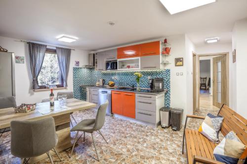 a kitchen with orange cabinets and a table and chairs at Penzion Karolinka in Karolinka