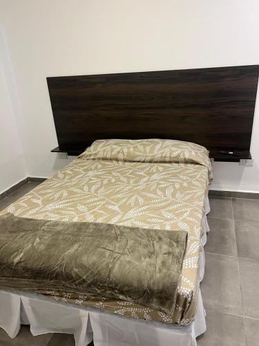 una camera da letto con un letto con testiera in legno di Moderno departamento con cochera en el corazón de Resistencia ideal para dos personas a Resistencia