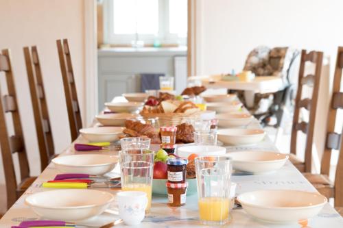 une longue table avec des bols et des assiettes de nourriture dans l'établissement Le Marais Aixois - Grande maison familiale, à Île-d'Aix