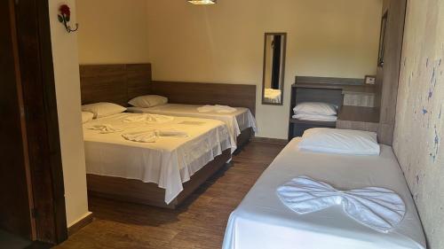 two beds in a room with two beds sidx sidx sidx sidx at Pousada Flor de Pequi in Serra do Cipo