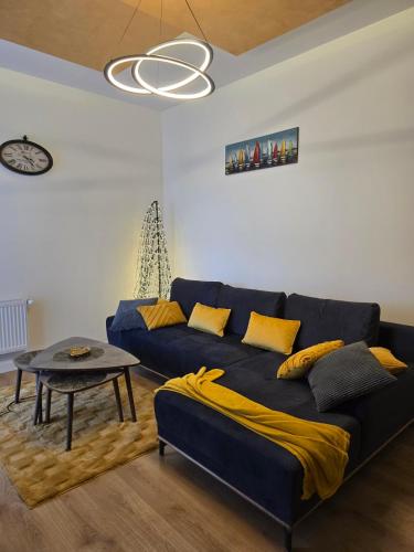 a living room with a blue couch and a table at Apartman Marjanović Palić in Palić