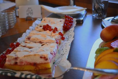 a piece of cake on a plate on a table at Pension Schlömmer in Sankt Gilgen