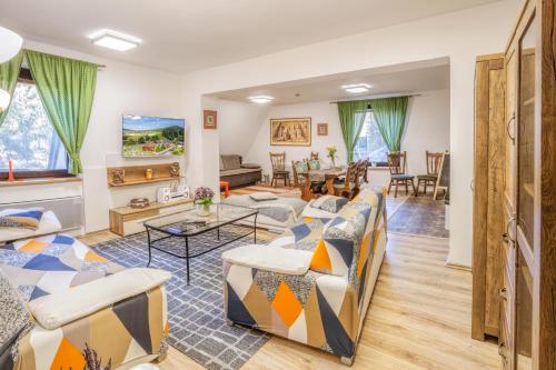 a living room with couches and a table at Penzion Karolinka in Karolinka