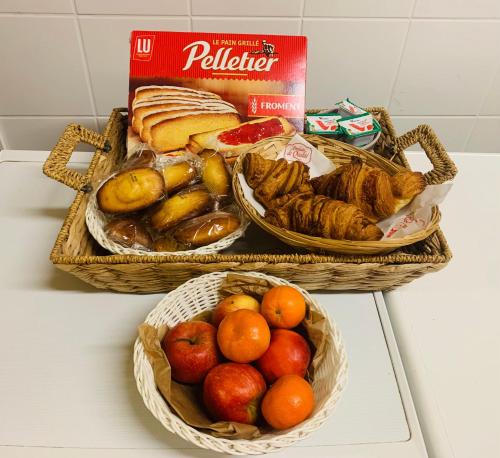 zwei Körbe mit verschiedenen Brotsorten und Früchten in der Unterkunft La Ferriere in Saint-Médard-en-Forez