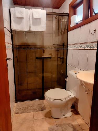 a bathroom with a shower with a toilet and a sink at Chale Chez Nous in Monte Verde