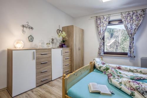 a childs bedroom with a bed and a dresser at Penzion Karolinka in Karolinka