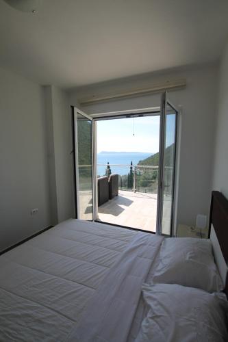 a bedroom with a bed and a view of the ocean at Apartments Marovic in Herceg-Novi