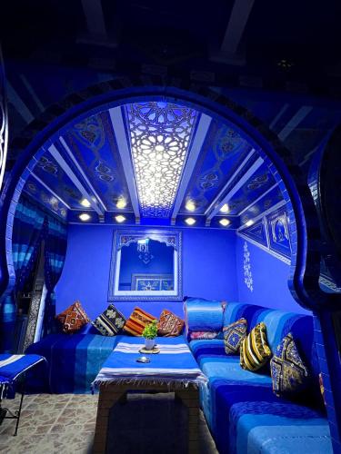 a blue room with a couch with pillows on it at DAR AMRANi in Chefchaouene