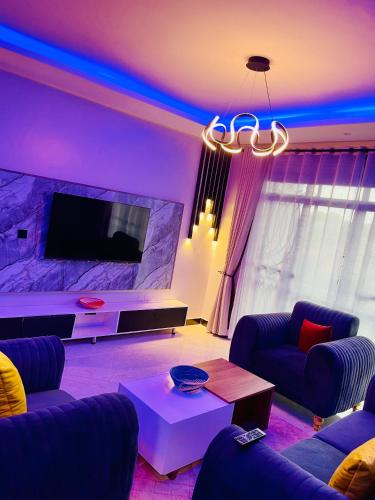 a living room with a couch and a tv at Enjoi Homes in Bulambiro