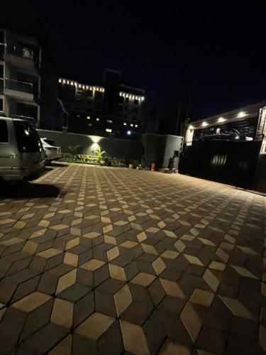a tiled sidewalk in a parking lot at night at Enjoi Homes in Bulambiro