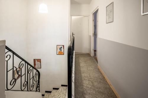 a stairway with a white wall and a white stair case at Cosy Green Clim Wifi Centre ville 2 pers in Lézignan-Corbières