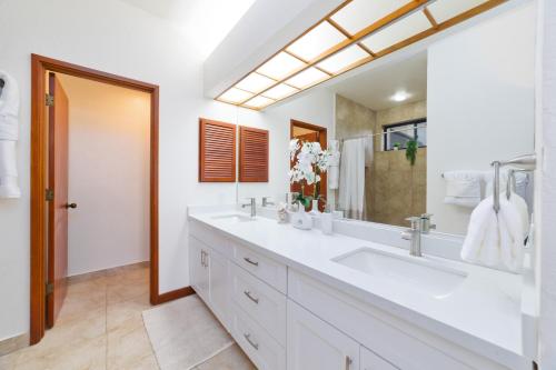 a bathroom with two sinks and a large mirror at Shores at Waikoloa 132 Hale Kai in Waikoloa