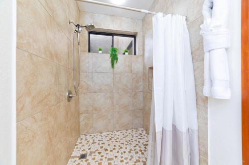 a bathroom with a shower with a shower curtain at Shores at Waikoloa 132 Hale Kai in Waikoloa