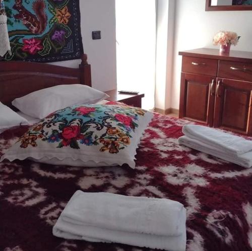 a bedroom with a bed with towels on it at Popasul Călătorului in Moisei
