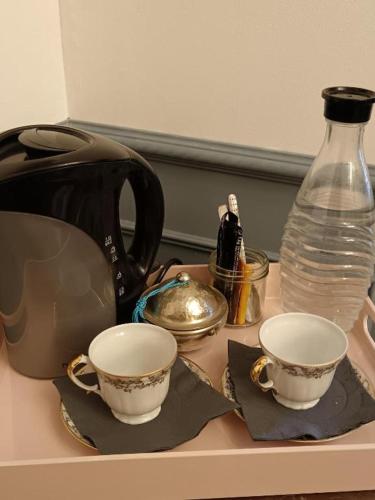 un comptoir avec deux tasses de thé et un vase dans l'établissement La belle époque, à Le Fouilloux