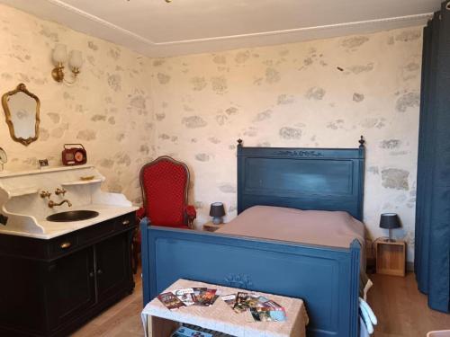 - une chambre avec un lit bleu et un lavabo dans l'établissement La belle époque, à Le Fouilloux