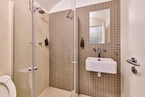 une salle de bain avec une douche avec un lavabo et des toilettes dans l'établissement Basilique du Sacré-Cœur, 9 min à pied, à Paris