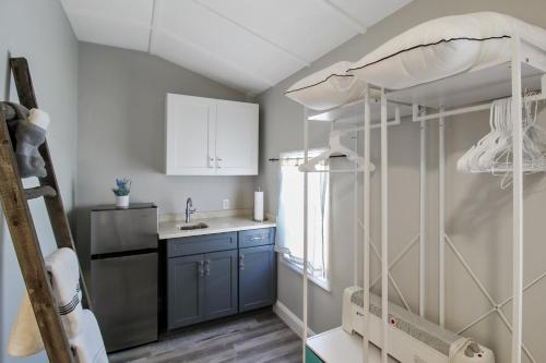 a small kitchen with blue cabinets and a refrigerator at Beautiful pool home in the historic village of Longboat Key - Close to beach in Longboat Key