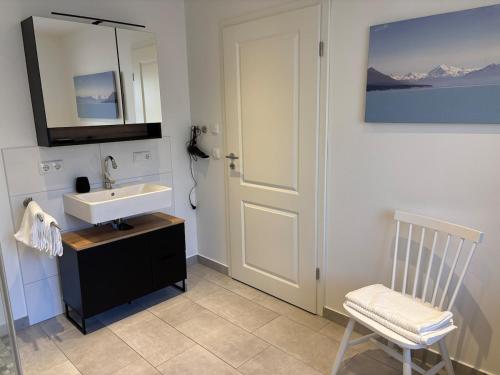 y baño con lavabo, silla y espejo. en Rosenhäusl, en Schönau am Königssee