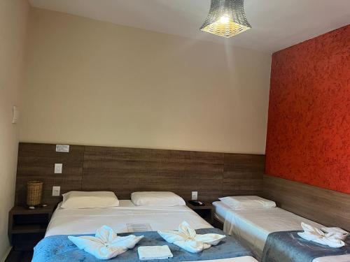 a hotel room with two beds with towels on them at Pousada Flor de Pequi in Serra do Cipo