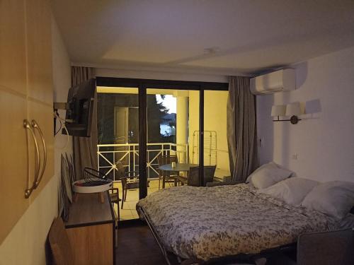 une chambre avec un lit et un balcon dans l'établissement Appartement 4 personnes ,résidence vue mer et jardin, piscine, parking, à Cannes