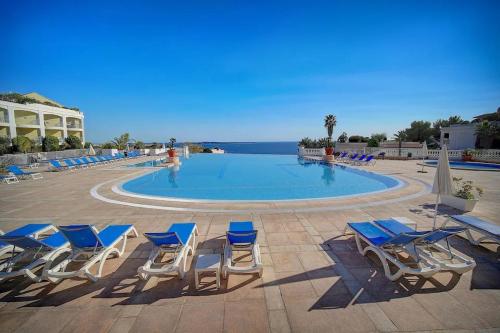 une piscine avec des chaises longues et l'océan dans l'établissement Appartement 4 personnes ,résidence vue mer et jardin, piscine, parking, à Cannes