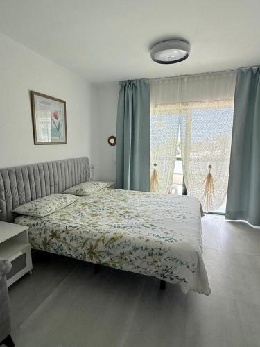 a bedroom with a bed and a large window at Al Sole Studios residence Playa Roca in Costa Teguise