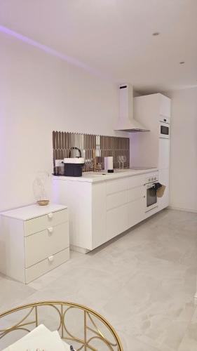 une cuisine avec des armoires blanches et un four à plaques de cuisson dans l'établissement Douceur Dorée, à Yville-sur-Seine